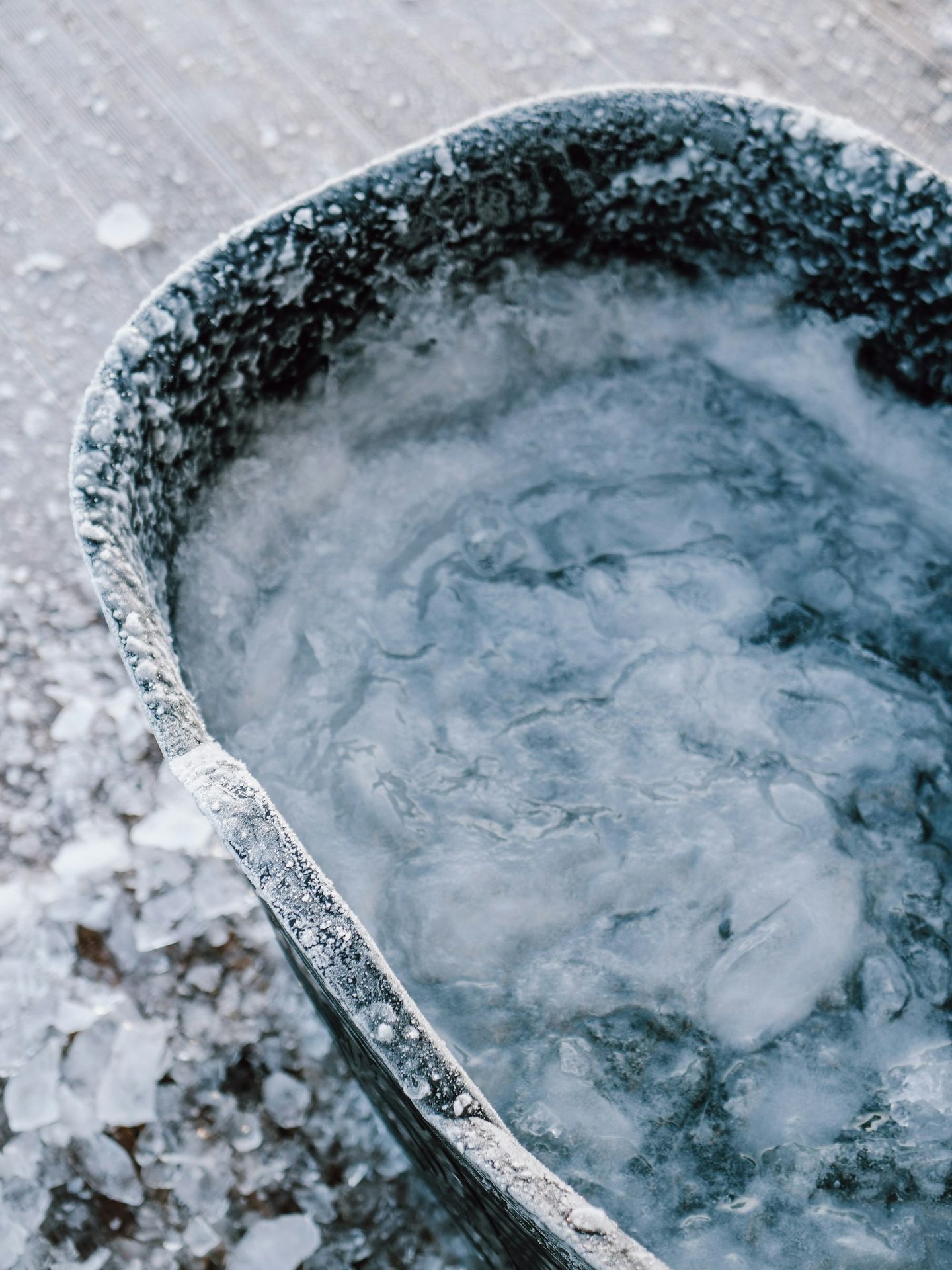 a bucket filled with ice sitting on top of a wooden floor
